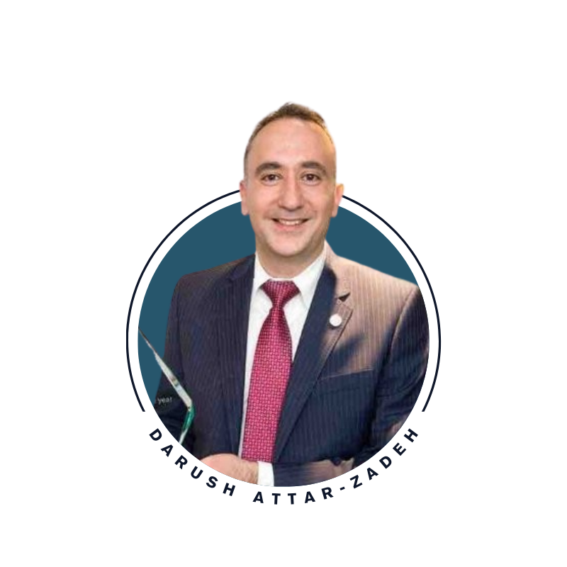 Portrait of Darush Attar-Zadeh in a dark suit and red tie, smiling.